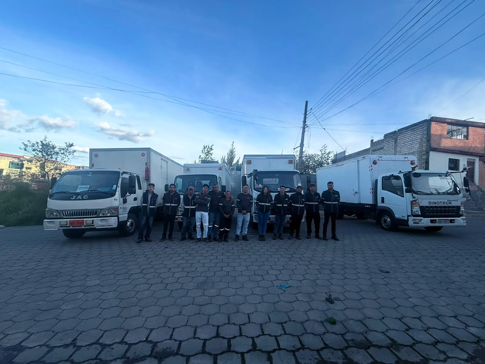 Conductores y personal de Curicamahnos frente a la flota de furgones en el patio de operaciones